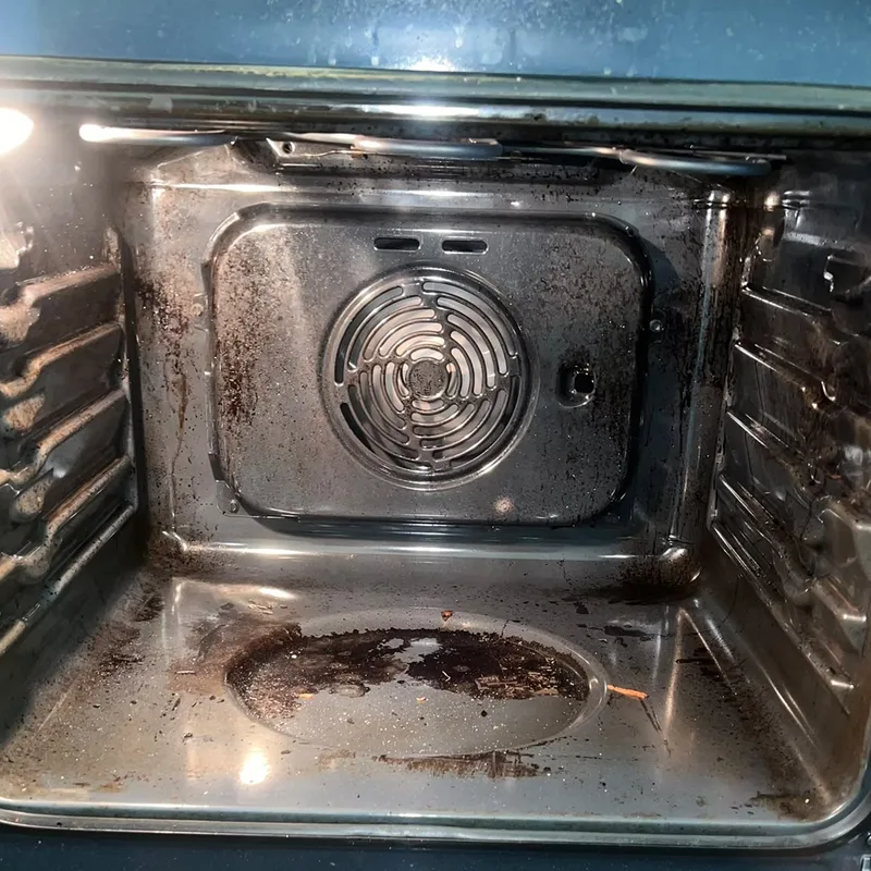 Before: built-in fan oven with burnt-on grease across the floor and back panel