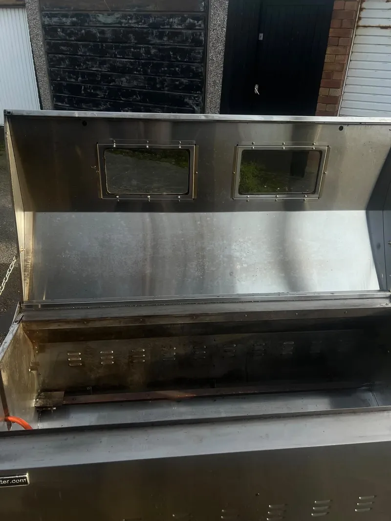 Hog roast machine with the lid open after cleaning, the steel clean inside